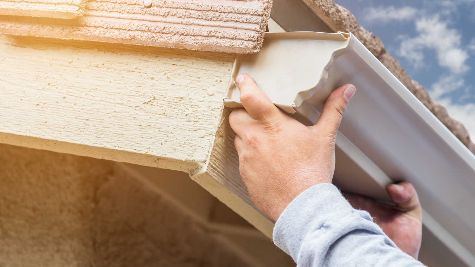 Technician repairing leaky gutter section